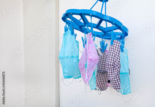 Washable DIY (Do it your self) medical face masks hanging after washing. Lack of mask during coronavirus infection pandemic crisis and reuse concept.  Selective focus with copy space. photo