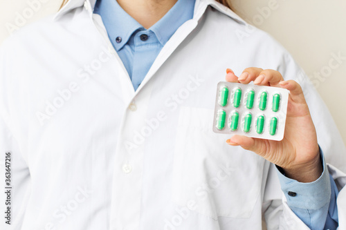 Female doctor showing pills in the hands of a close-up. The appointment of treatment.