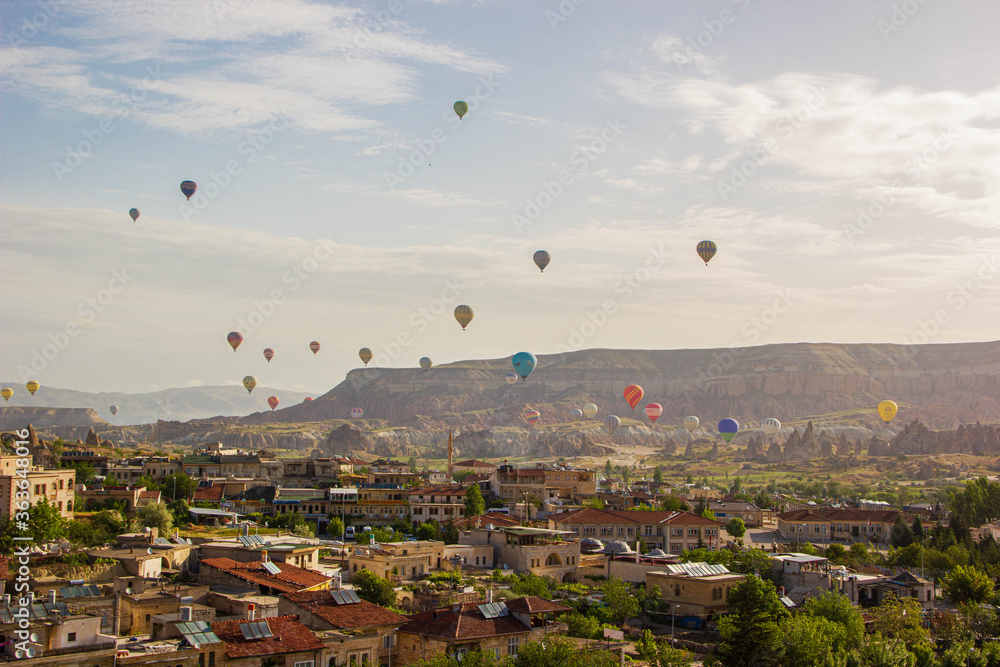 top view of Cappadocia houses and balloons at sunrise