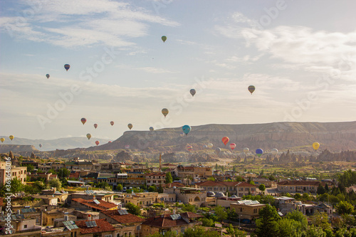 top view of Cappadocia houses and balloons at sunrise