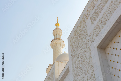 Foto Abu Dhabi, UAE - October 5, 2019 - Beautiful mosque of the tower of the white marble minaret on a background of blue sky