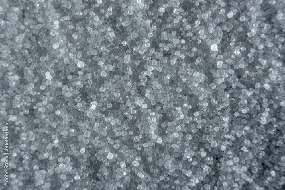 Fullscreen macro closeup with shallow depth of field of small grains of fine salt. Texture. Graphic design.