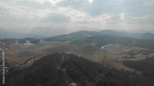 The peaks of high mountains are covered with dense forests. Panoramic view of the valley at the 
foot of the mountains.