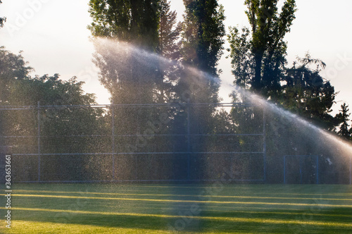 Irrigation of the football field lawn.The system works on fresh green grass in a football stadium.Close-up of irrigation.