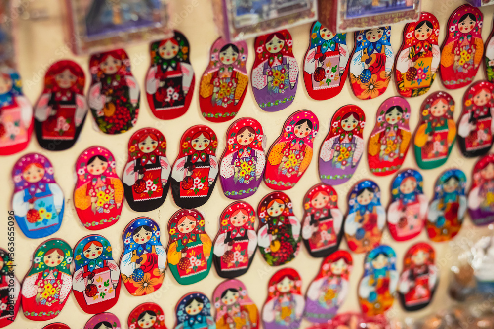 View of traditional souvenirs from Saint-Petersburg, Russia, with fridge magnets of russian dolls, matryoshka, balalaika, ballet dancer, vodka bottle at local vendor souvenir shop on Nevsky Prospect