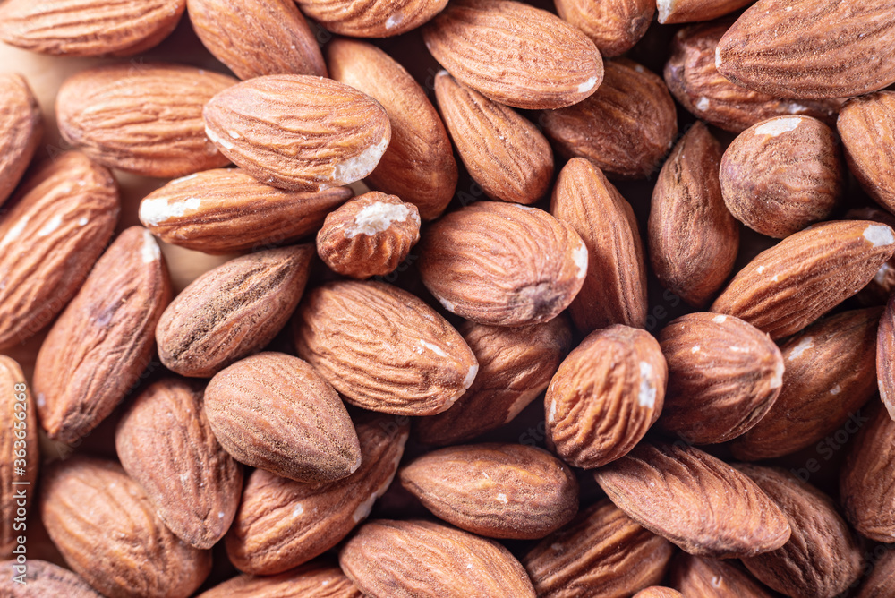 Closeup of shiny peeled almond seeds. Peeled almond texture. Superfood. Natural food. Closeup of shiny peeled almond seeds. Peeled almond texture. Superfood. Natural food.