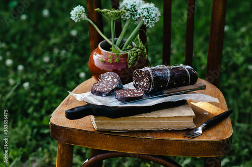 Dessert of cookies, Sweet chocolate sausage (confectionery wurst) on white plate, close up. Rustic style.