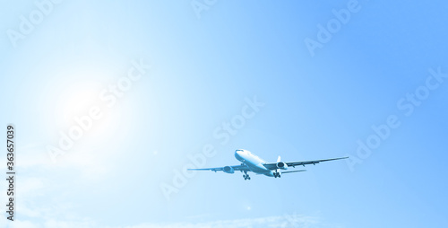 Airplane on a background of blue sky. White sun, transport, travel