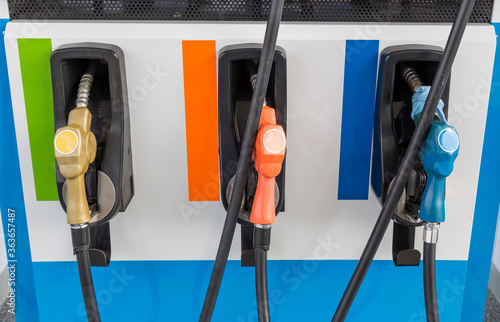 Fuel Pump, Gas Station, Gasoline.Colorful Petrol pump filling nozzles isolated on white background , Gas station in a service in warm sunset.Head fuel vehicle refueling facility in Asia photo