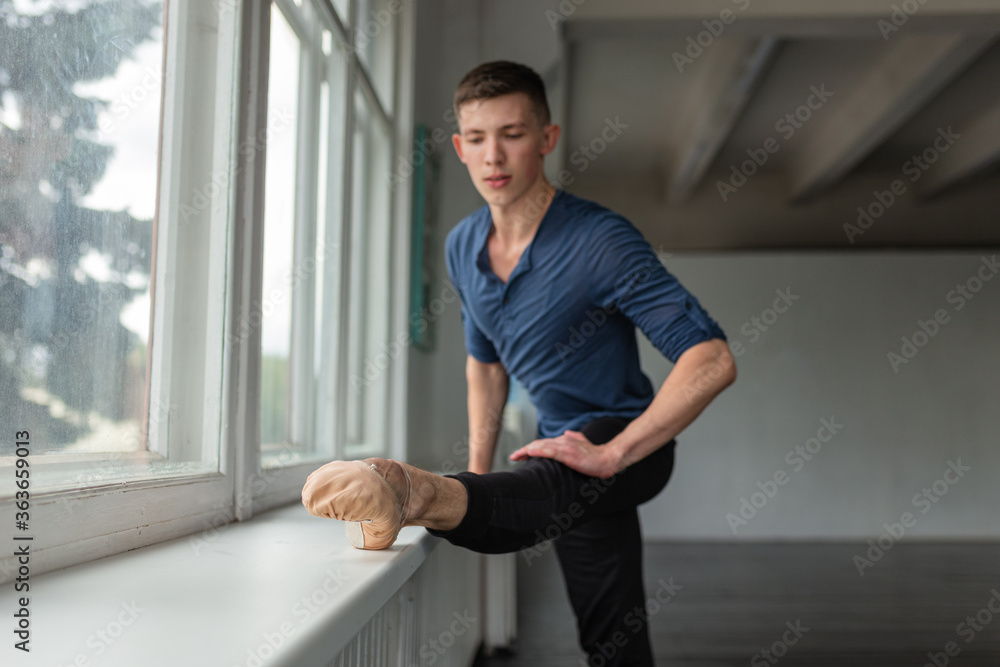 Young man training ballet at school. Young man training ballet at school.