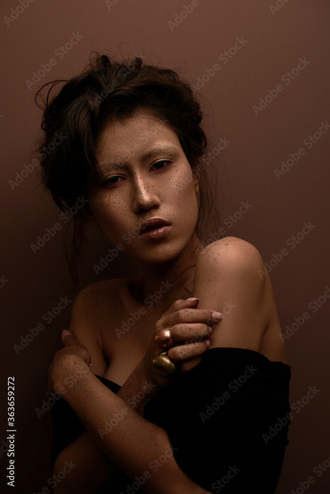 Stunning portrait of an asian girl with the hands crossed over her body and fake freckless Stunning portrait of an asian girl with the hands crossed over her body and fake freckless