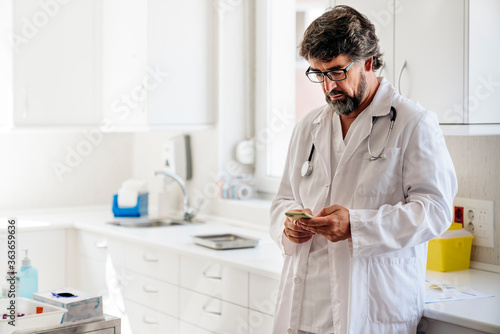 Portrait of a doctor looking at his phone