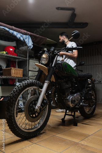 Bearded biker standing in garage photo