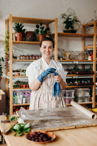 Portrait of a beauty caucasian woman in an apron in a crative studio. She is looking at the camera and smiling photo