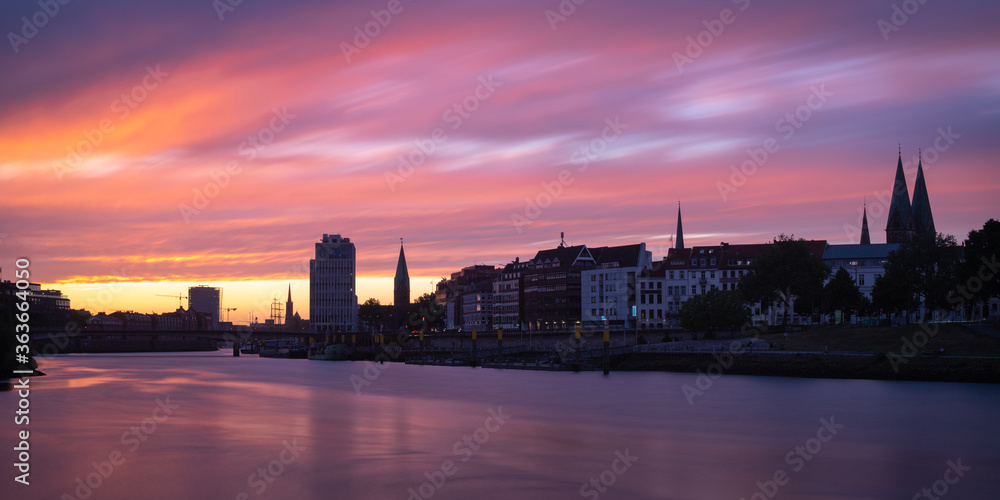 panorama of the river Weser in Bremen, Germany with city center and beautiful clouds at sunset