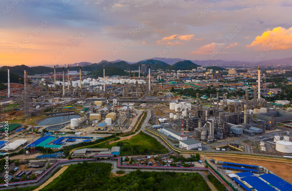 Aerial view of oil refinery plant chemical factory and power plant with many storage tanks and pipelines at sunset.
