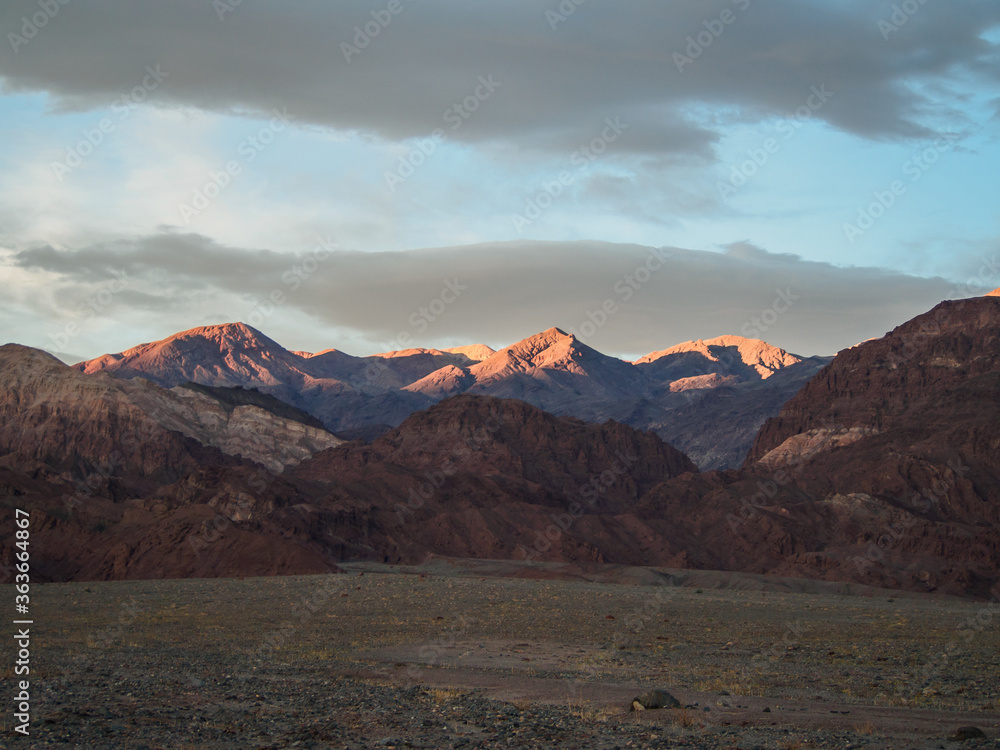 Death Valley. The tops of the mountains are lit by the last rays of the setting sun.