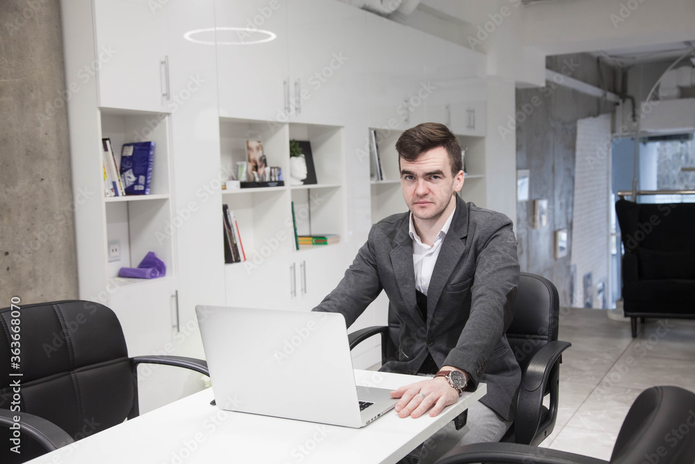 young businessman works in an office with a laptop young businessman works in an office with a laptop