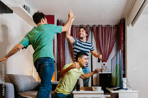 Friends watching a soccer match at home photo