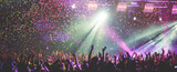 A crowded concert hall with scene stage lights, rock show performance, with people silhouettes during live music show performance with crowd of audience