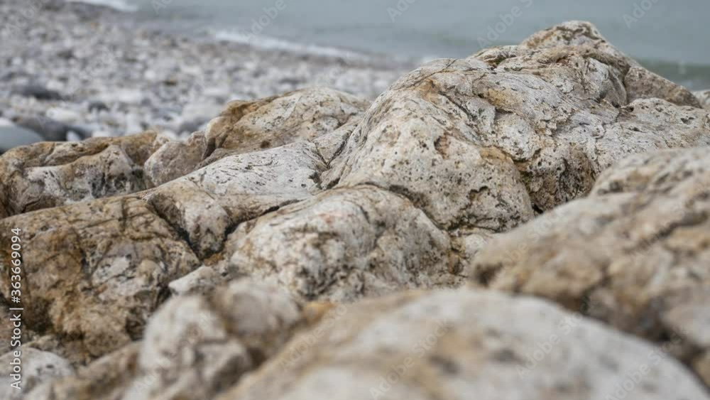 Rocky pebble stone shoreline with ocean waves background marine landscape close-up right dolly Rocky pebble stone shoreline with ocean waves background marine landscape close-up right dolly