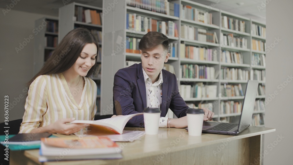 Two caucasian university students preparing to exam in library Two caucasian university students preparing to exam in library
