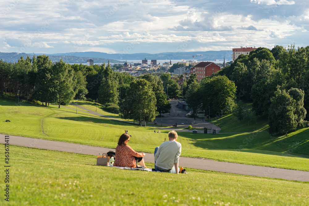 Young couple sitting and resting in the nature and with a view on the sea in Oslo Norway Young couple sitting and resting in the nature and with a view on the sea in Oslo Norway
