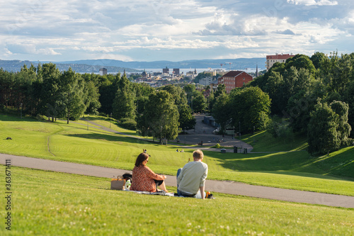 Young couple sitting and resting in the nature and with a view on the sea in Oslo Norway