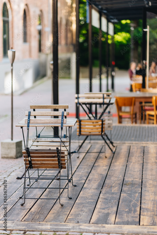 Outdoor restaurant with fresh flowers on the wooden table Outdoor restaurant with fresh flowers on the wooden table