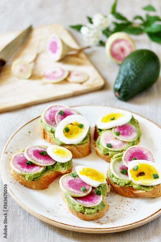 watermelon radish sandwich with avocado and egg. healthy balanced breakfast. bright toast