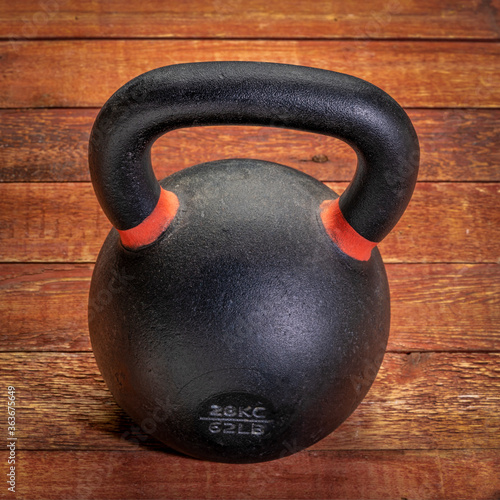 Fototapeta Naklejka Na Ścianę i Meble -  heavy iron kettlebell on a rustic wood background, fitness and gym concept