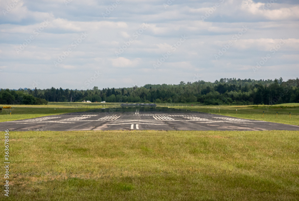 Small airport runway in front of forest