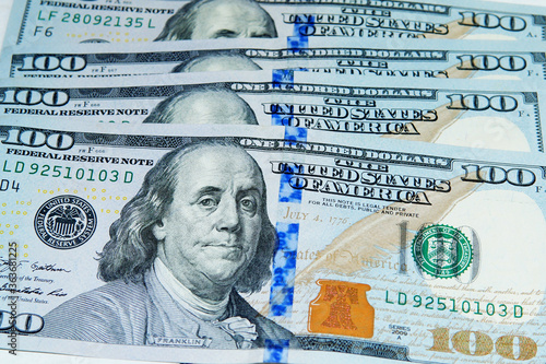 Close up view of a bunch of 100 dollar bills. Taken inside a softbox with white lighting