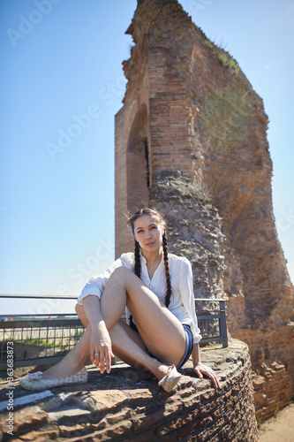 young woman sitting near the wall
