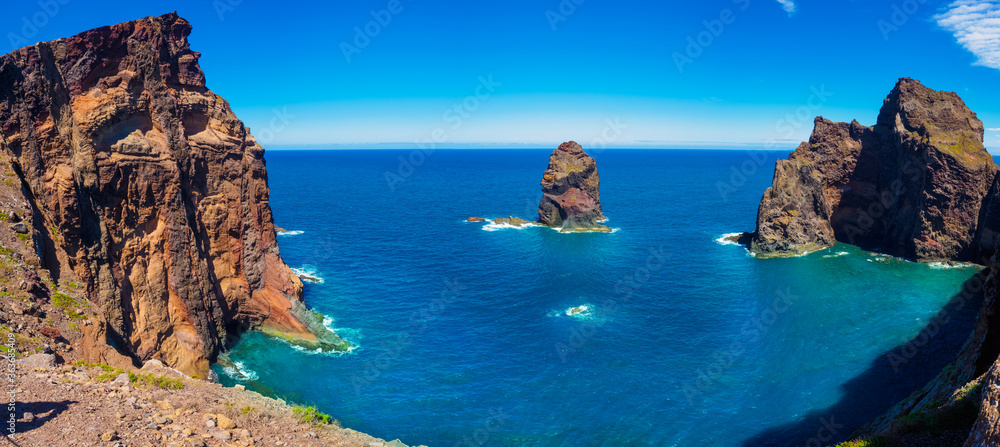 Aerial panoramic view of the ocean scape and mountain cliffs in Ponta de Sao shore in Madeira island, Portugal - obrazy, fototapety, plakaty 