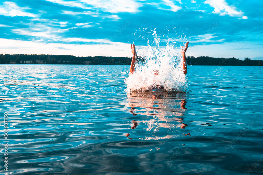 Finnish girl swimming in the lake during warm scandinavian midsummer