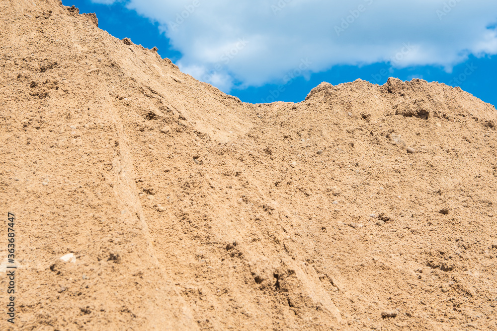 a mountain of sand against a blue sky. building material