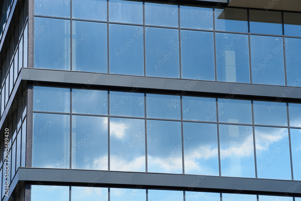 facade of a modern building on a bright Sunny day, blue sky and clouds reflecting in a glass, beautiful exterior of the new building facade of a modern building on a bright Sunny day, blue sky and clouds reflecting in a glass, beautiful exterior of the new building