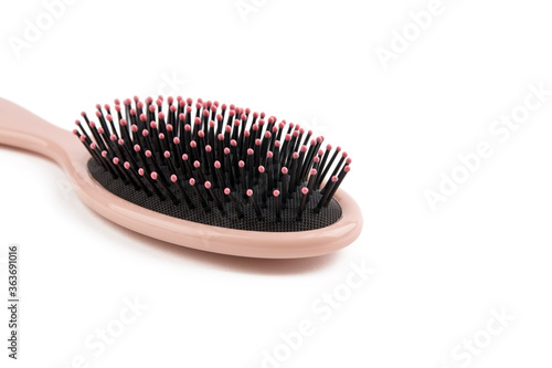 pink colored hairbrush isolated on a white background. comb for hairstyle and hygiene care.