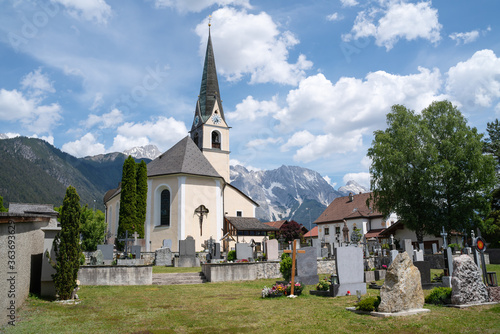 Traditional Austrian village church and cemetery in the alpine mountains, Obsteig, Tirol, Austria