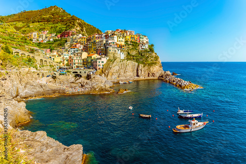 Fototapeta Naklejka Na Ścianę i Meble -  A panorama view of boats noored in front of the village of Manarola, Cinque Terre, Italy in the summertime