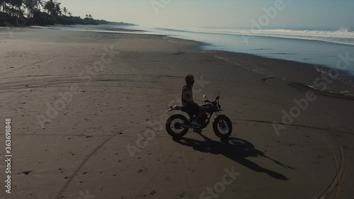 Tired biker having rest on an evening ocean beach