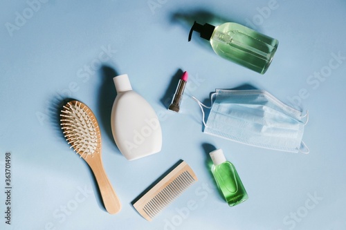 Beauty salons reopen after coronavirus COVID-19 lockdown. Flat lay photo stuff. Shampoo  hair brushes  cosmetics and disposable face mask  sanitizer gel