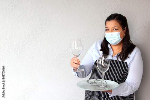 Latin woman waitress with tray and glasses working with face masks and protective gloves, new normal by covid-19 photo