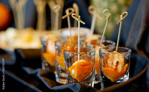 orange treats in a glass on a table with a cloth 