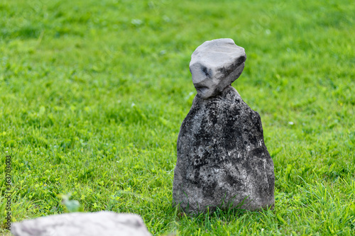a stone figure stands on the grass