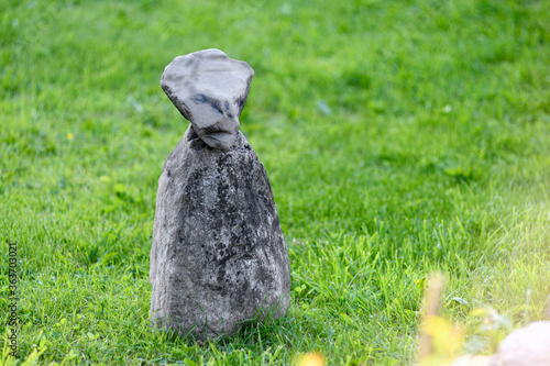 a stone figure stands on the grass