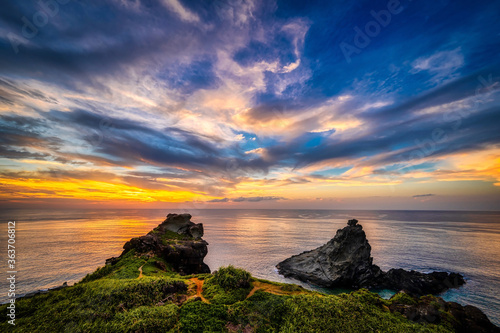 The rocky coastline and lighthouse of Ogan-zaki, Ishigaki Island, Okinawa, at sunset photo