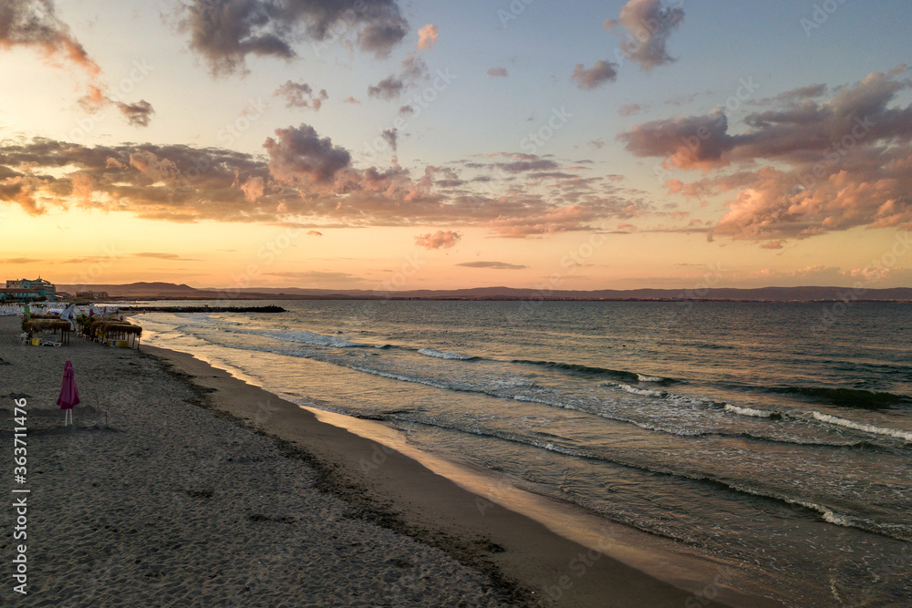Sea surface with blue water waves under yellow and purple sunset sky. Sea surface with blue water waves under yellow and purple sunset sky.