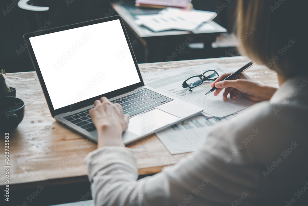 Rear view mockup image of a woman's hand working on a laptop with blank white desktop copy space screen on a desk Rear view mockup image of a woman's hand working on a laptop with blank white desktop copy space screen on a desk
